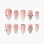 Pink ombre press-on nails with rhinestones, glitter, and 3D decorative accents