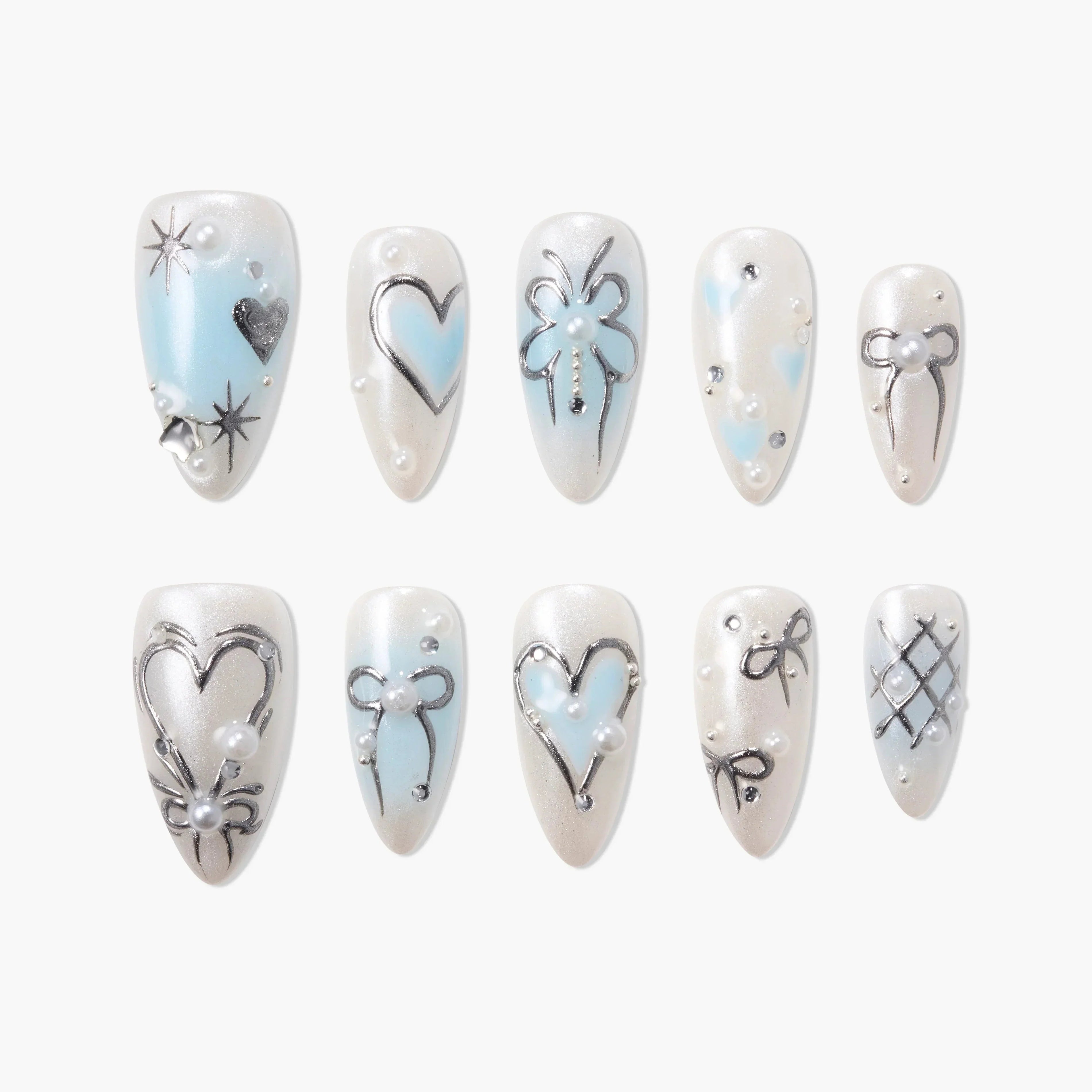 Handmade press-on nails with blue and silver heart, bow, and pearl accents on white base