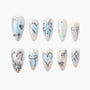 Handmade press-on nails with blue and silver heart, bow, and pearl accents on white base