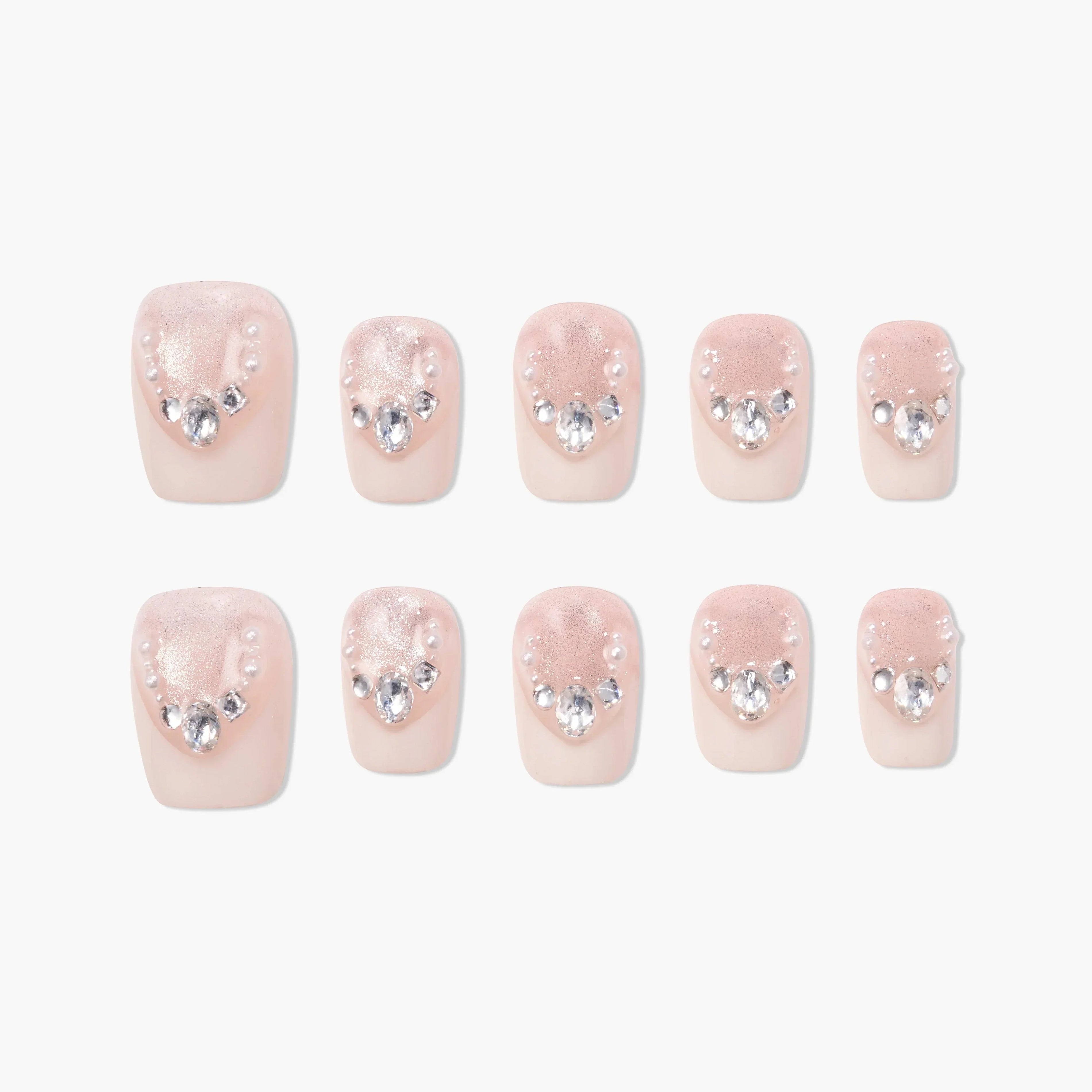 Set of blush pink press-on nails with pearl and rhinestone accents, arranged on white background.