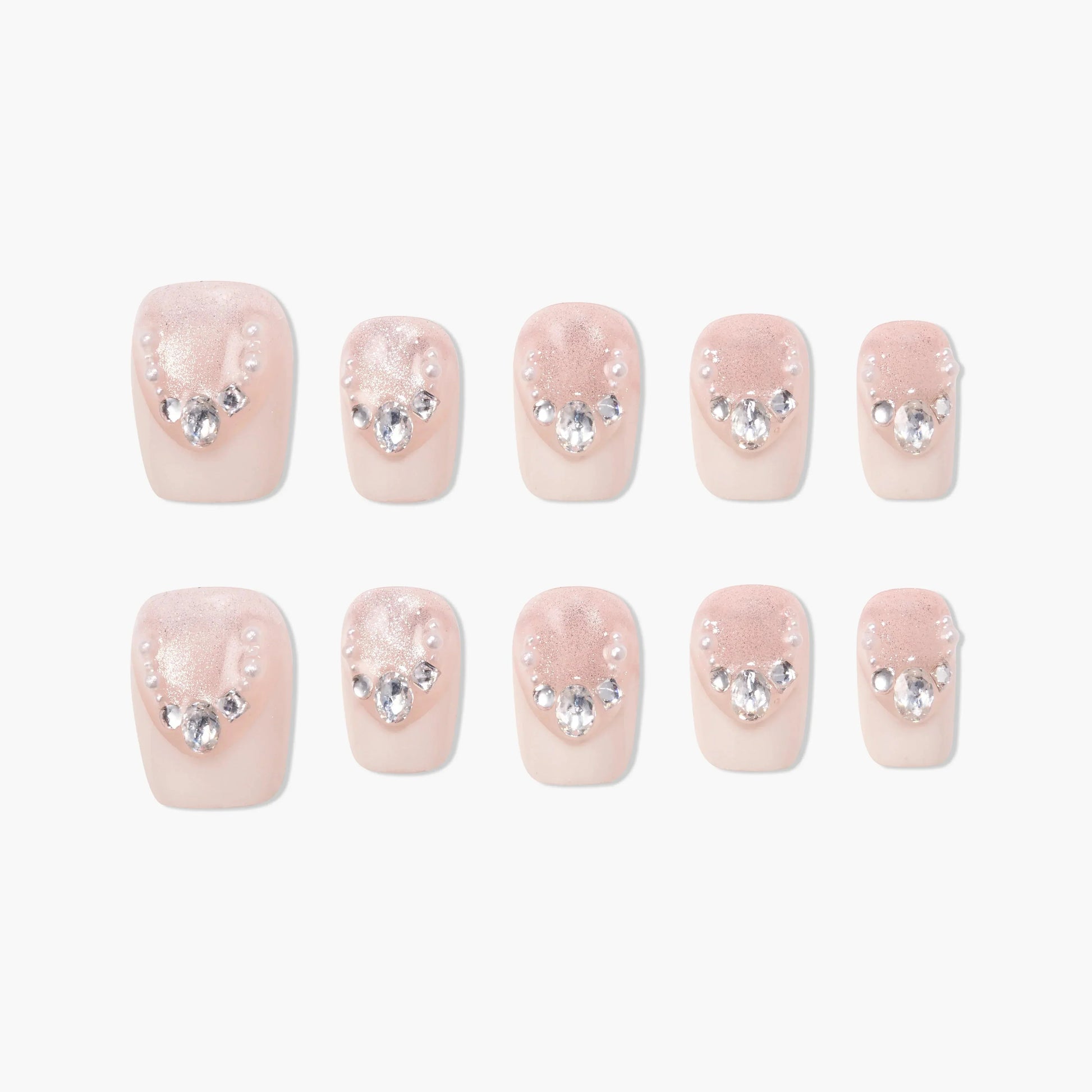 Set of blush pink press-on nails with pearl and rhinestone accents, arranged on white background.