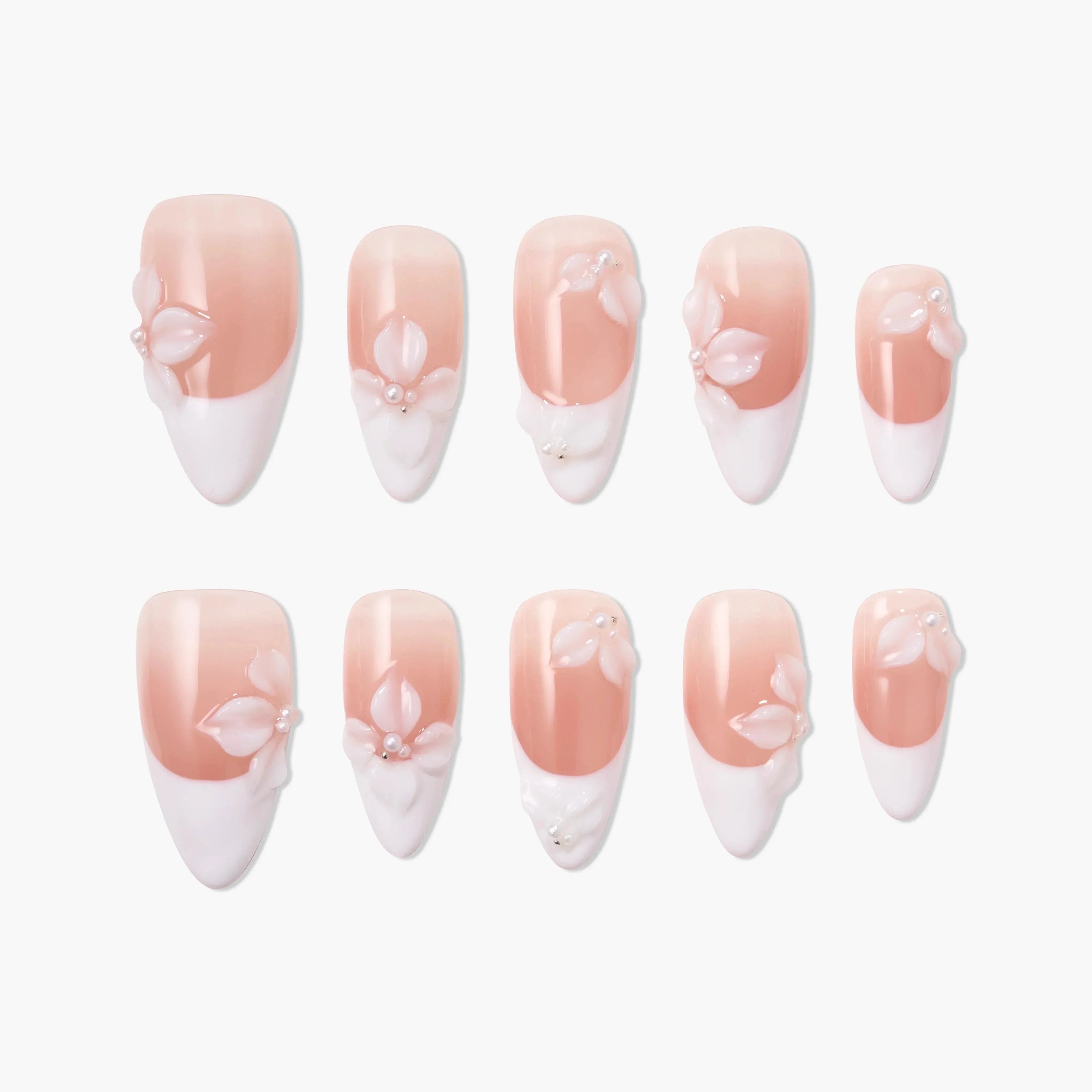 Handmade pink and white press-on nails with 3D floral and pearl design, arranged on white background
