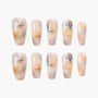 Handmade press-on nails with watercolor floral design in soft peach and yellow tones