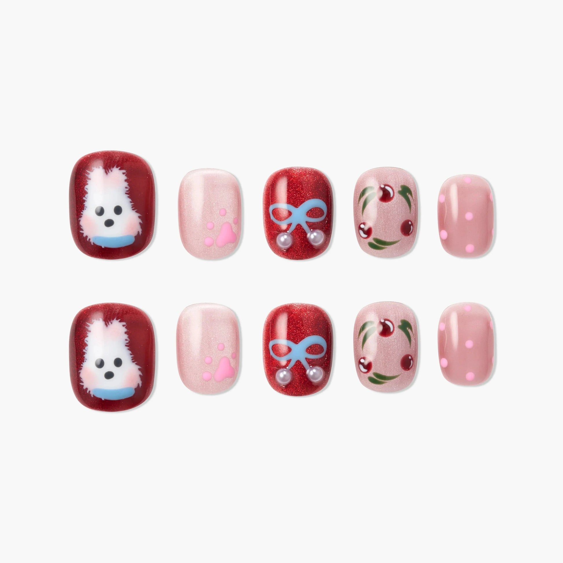 Handmade press-on nails with red, pink, and glitter finishes, featuring dog, paw print, bow, cherry, and polka dot designs.