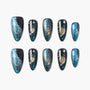 Galaxy-themed press-on nails with blue, gold, and glitter accents, featuring star and planet designs