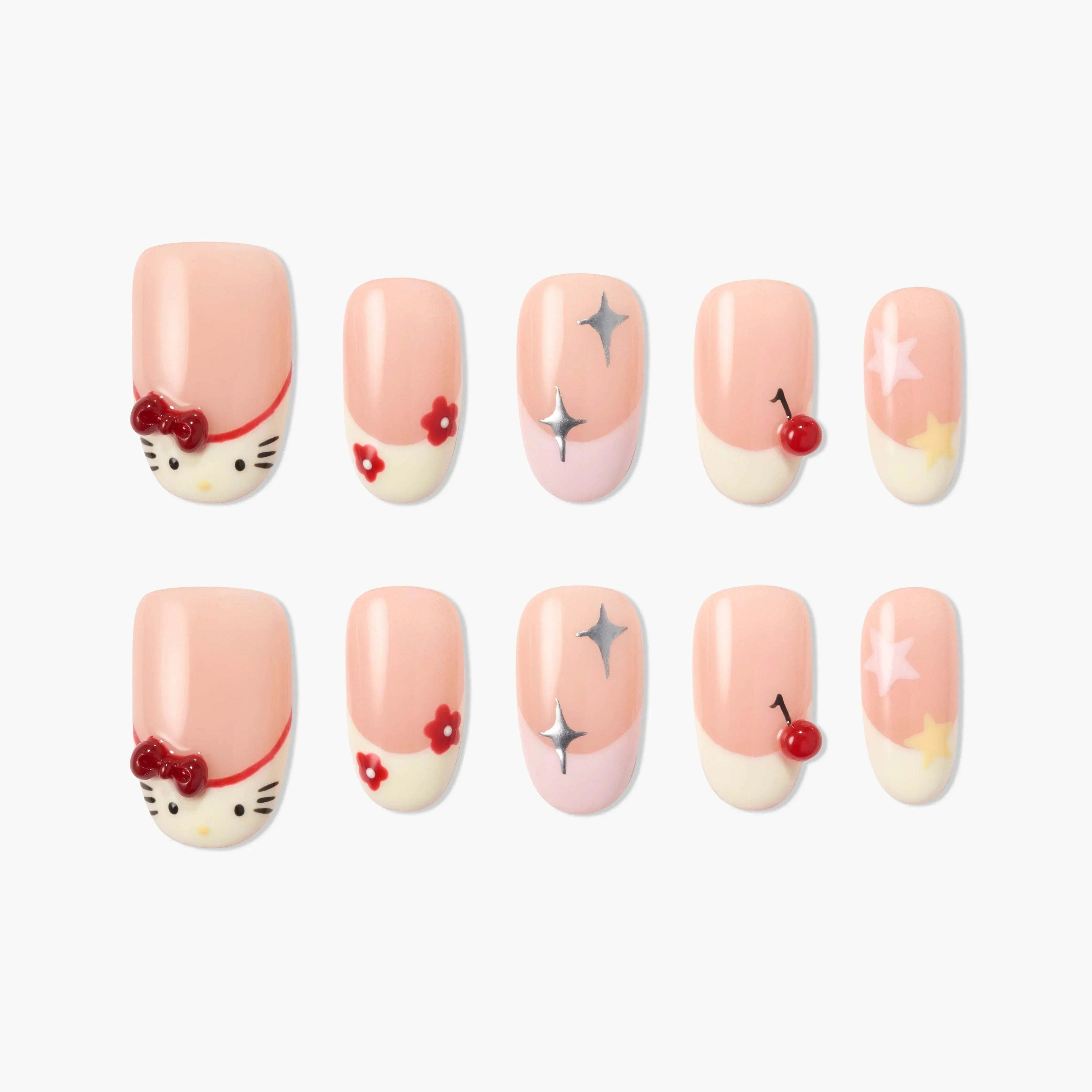 Cute pink press-on nails with cartoon faces, stars, cherries, flowers, and glitter accents