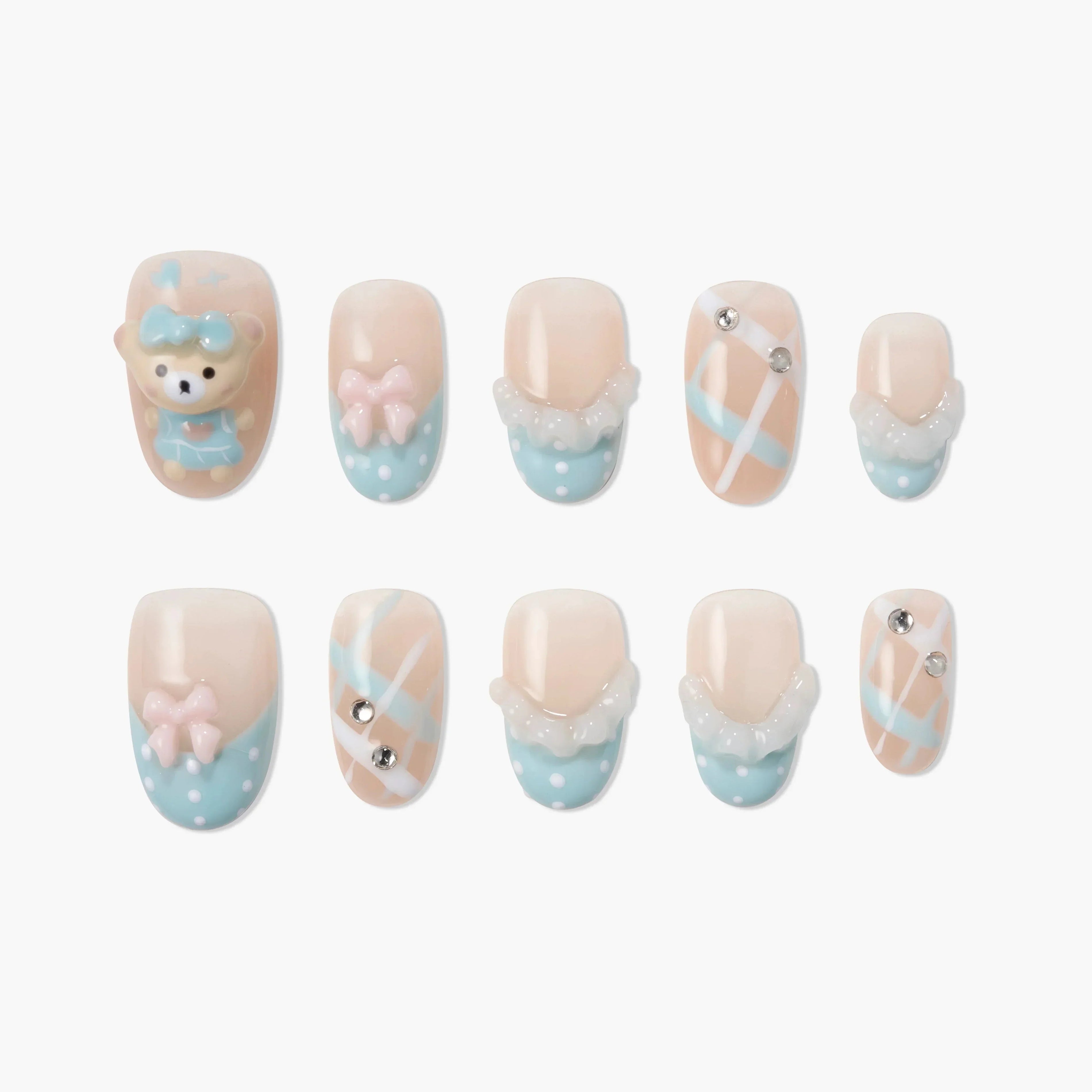Cute blue and pink handmade press-on nails with bear, bows, gems, and plaid details