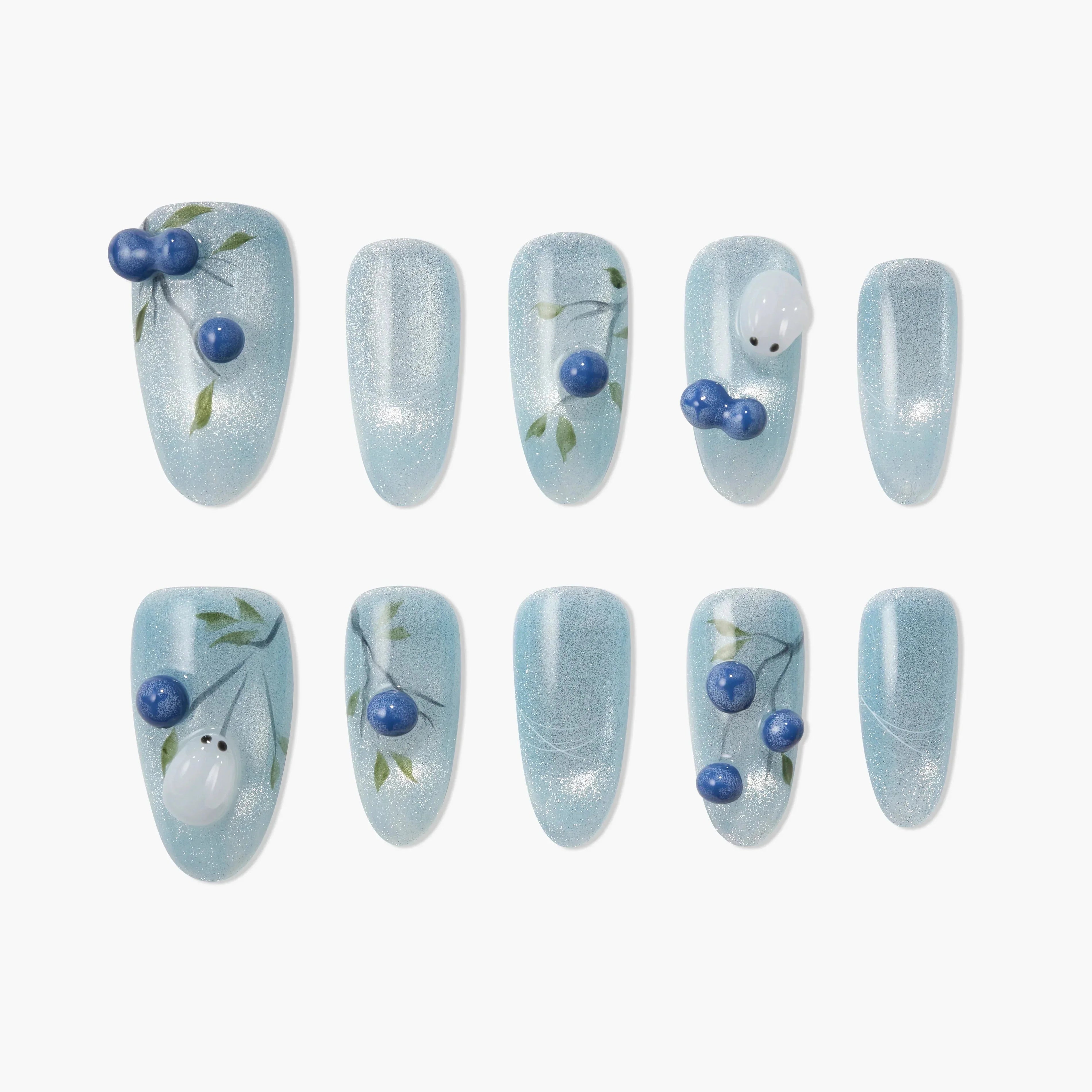 Handmade press-on nails with blue shimmer, botanical designs, and 3D blue berries on a white background
