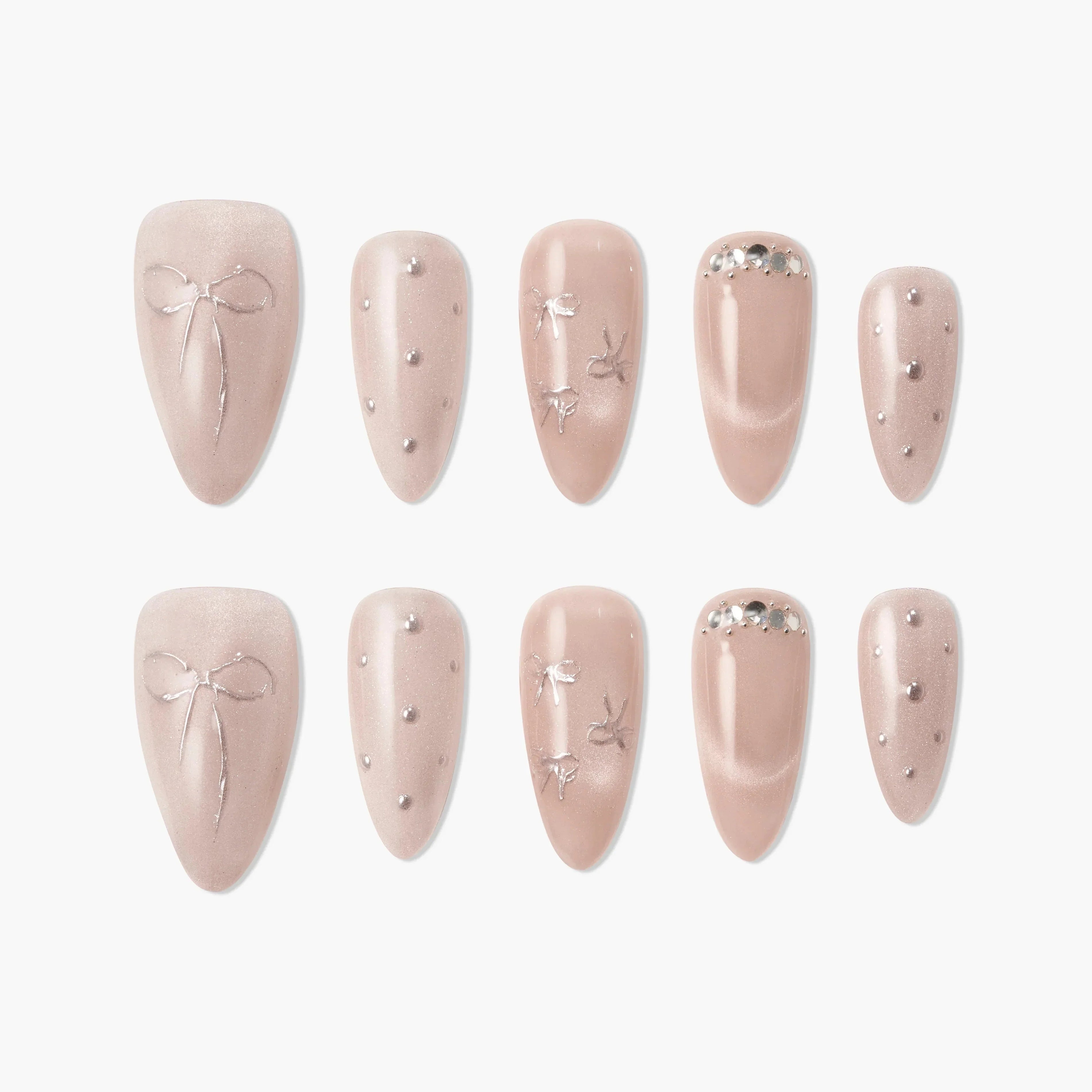 Blush pink press-on nails with silver bows, rhinestones, and pearl accents, elegant design.