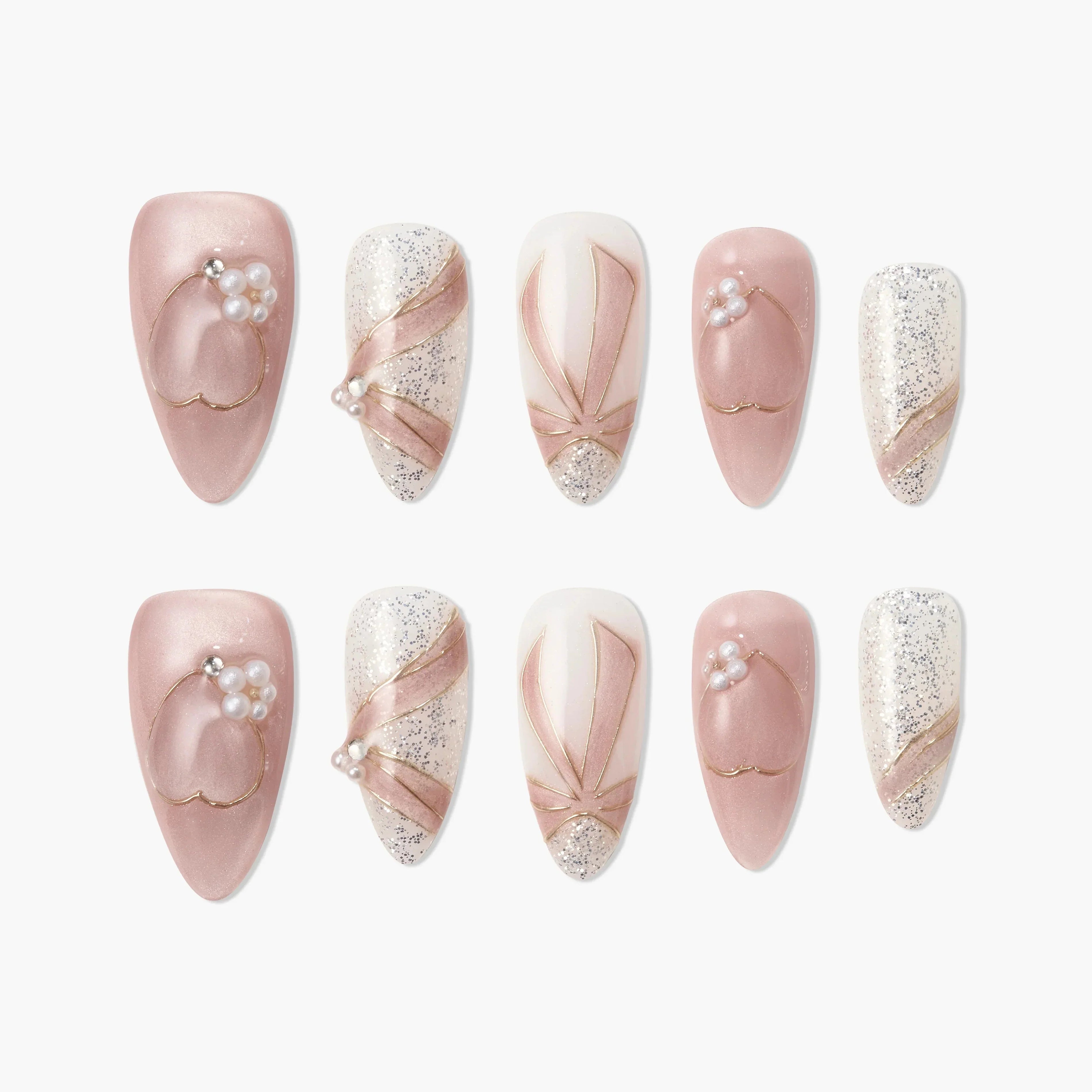 Pink and white press-on nails set with pearl accents, glitter, and gold ribbon details.