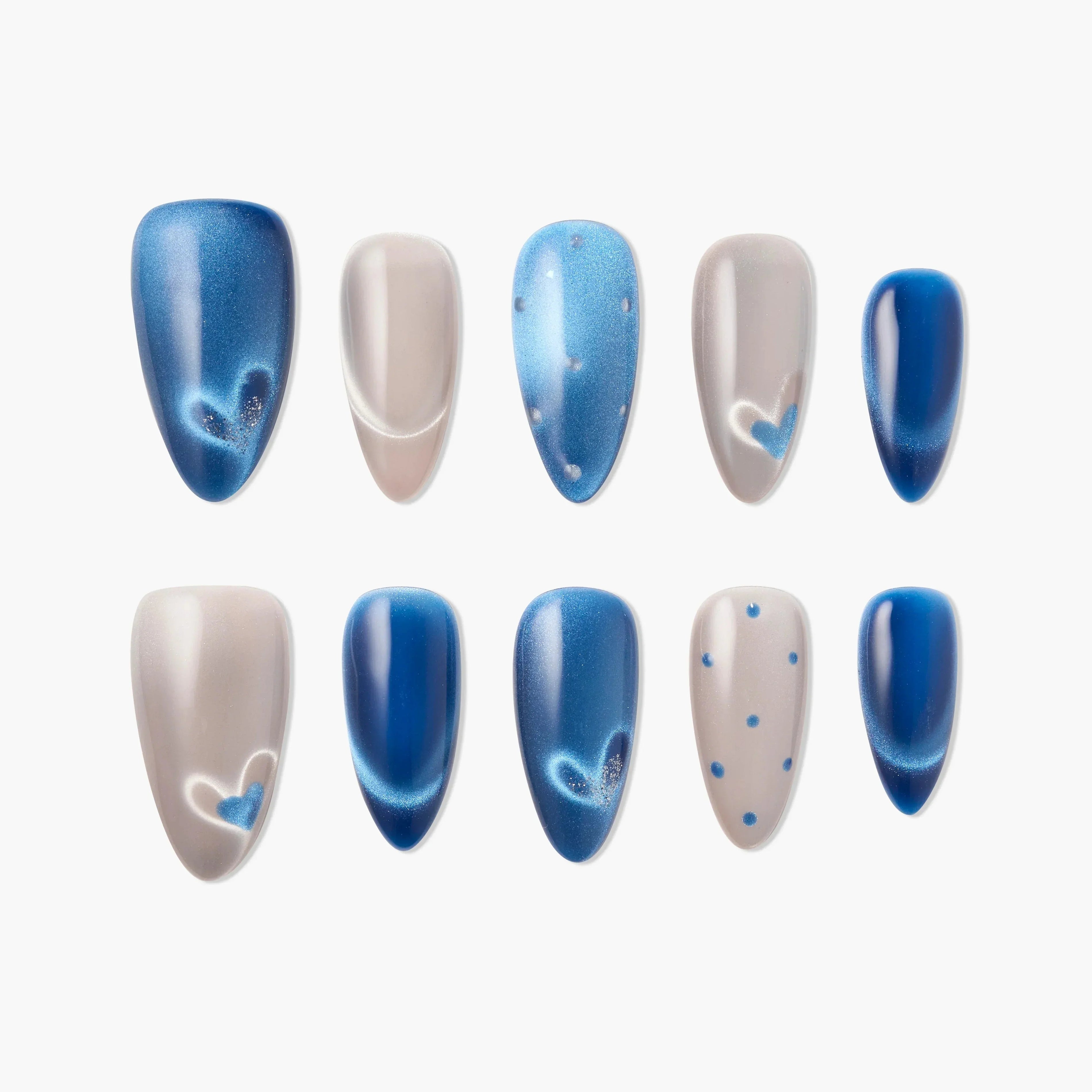 Handmade blue and nude press-on nails with heart and polka dot designs on white background