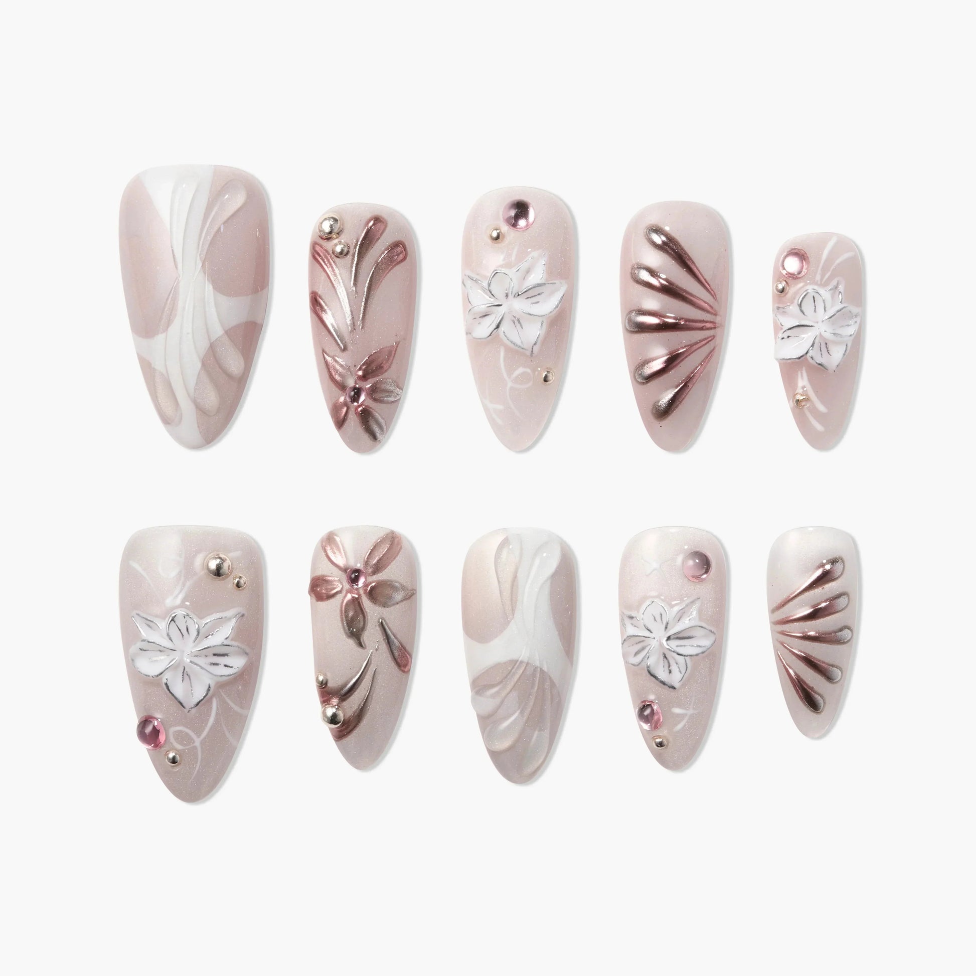 Handmade press-on nails in nude and white with 3D floral and metallic designs, gem accents
