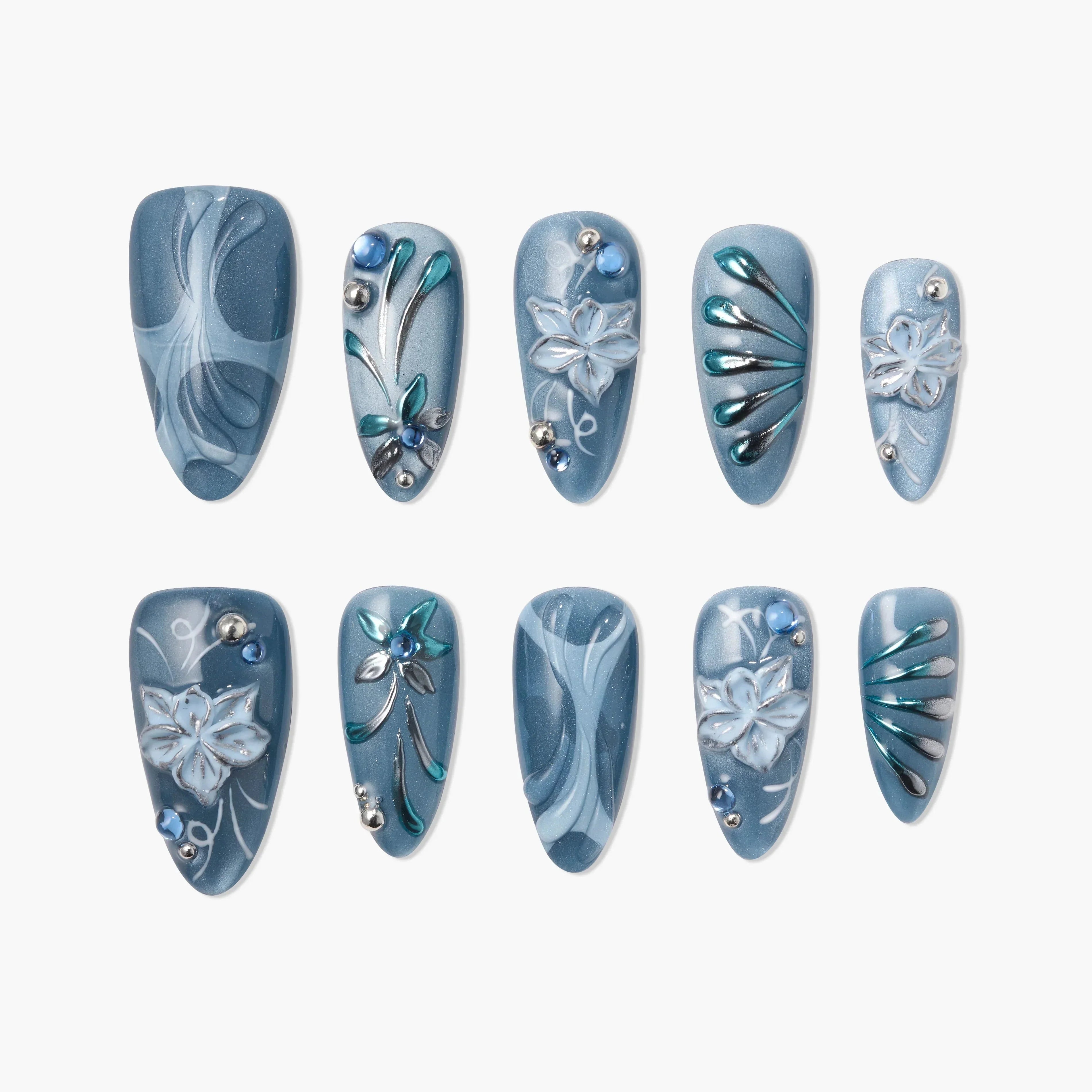Handmade blue press-on nails with 3D floral designs, silver accents, and rhinestones on white background