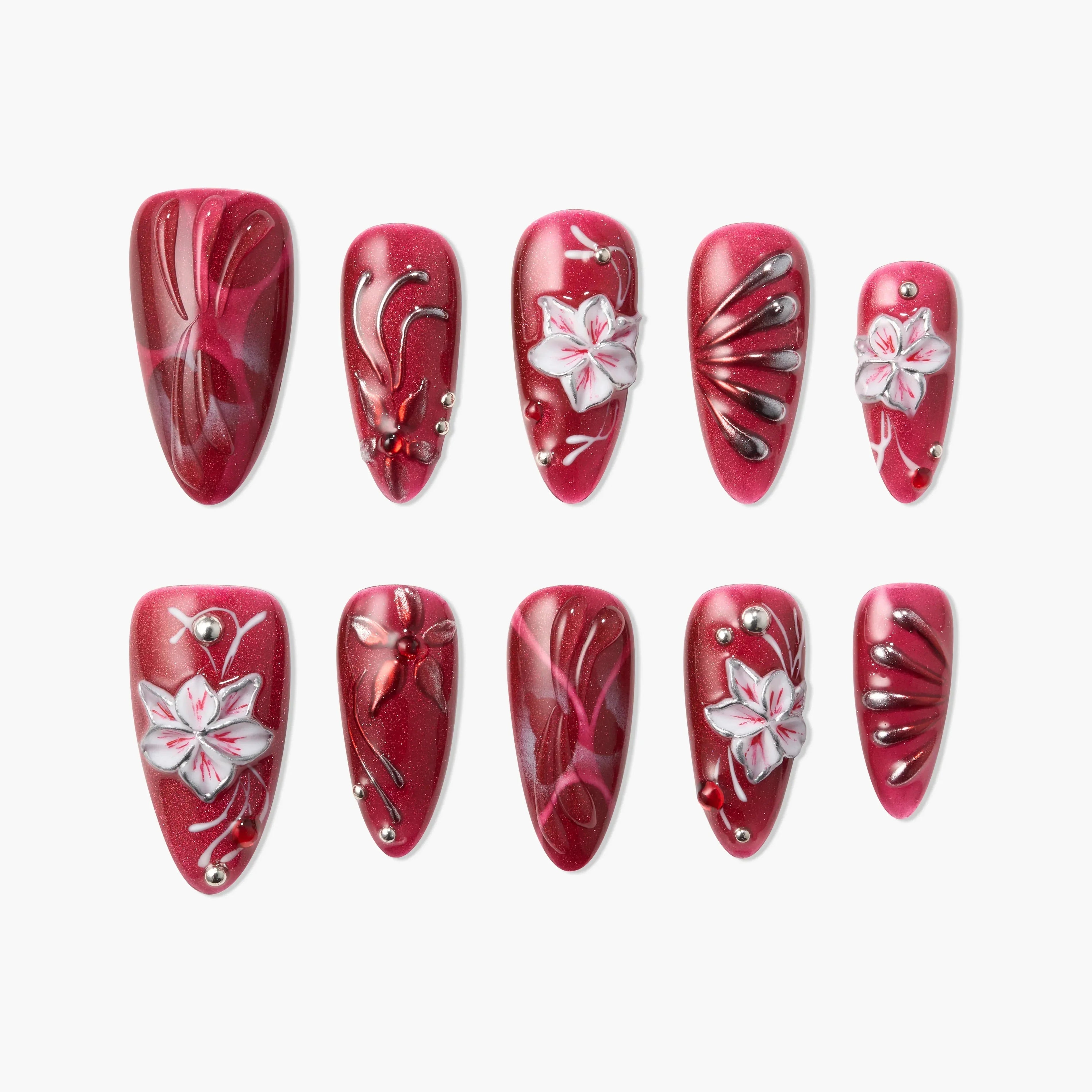 Red press-on nails with white 3D floral designs, rhinestones, and glitter accents.
