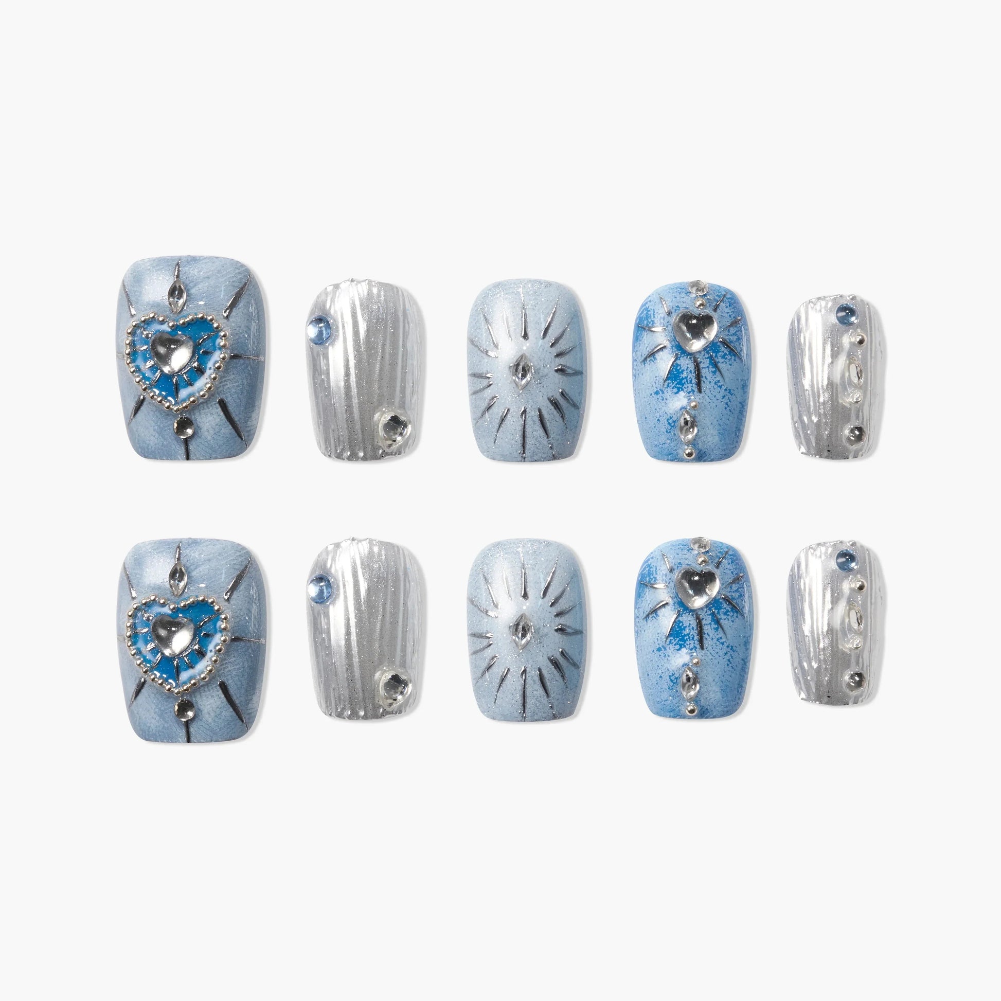 Blue and silver press-on nails with heart, gem, and starburst designs, arranged on white.