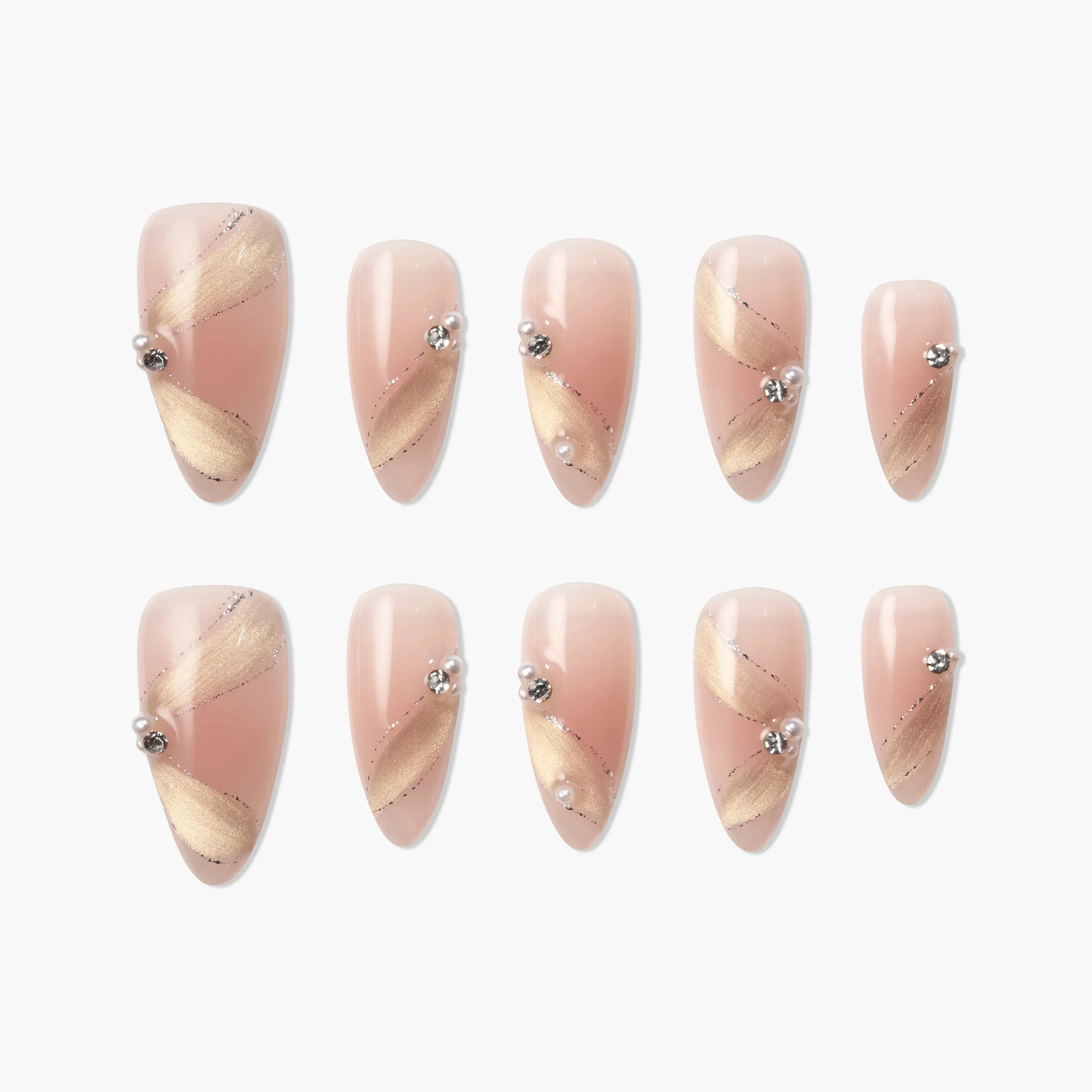 Almond-shaped press-on nails in pink with gold diagonal accents and pearl rhinestone details.
