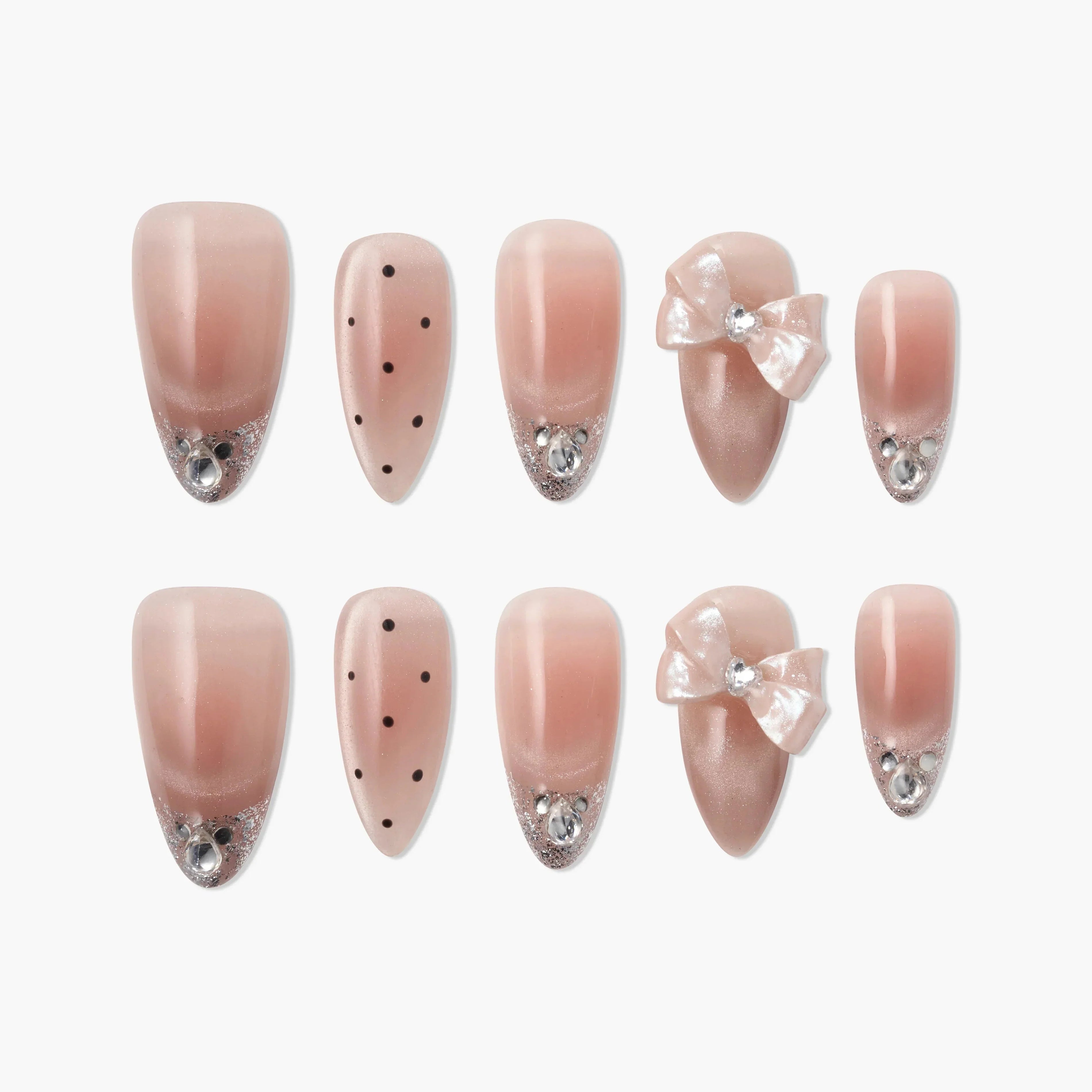 Pink press-on nails with rhinestones, polka dots, glitter tips, and decorative bows