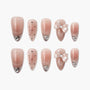 Pink press-on nails with rhinestones, polka dots, glitter tips, and decorative bows