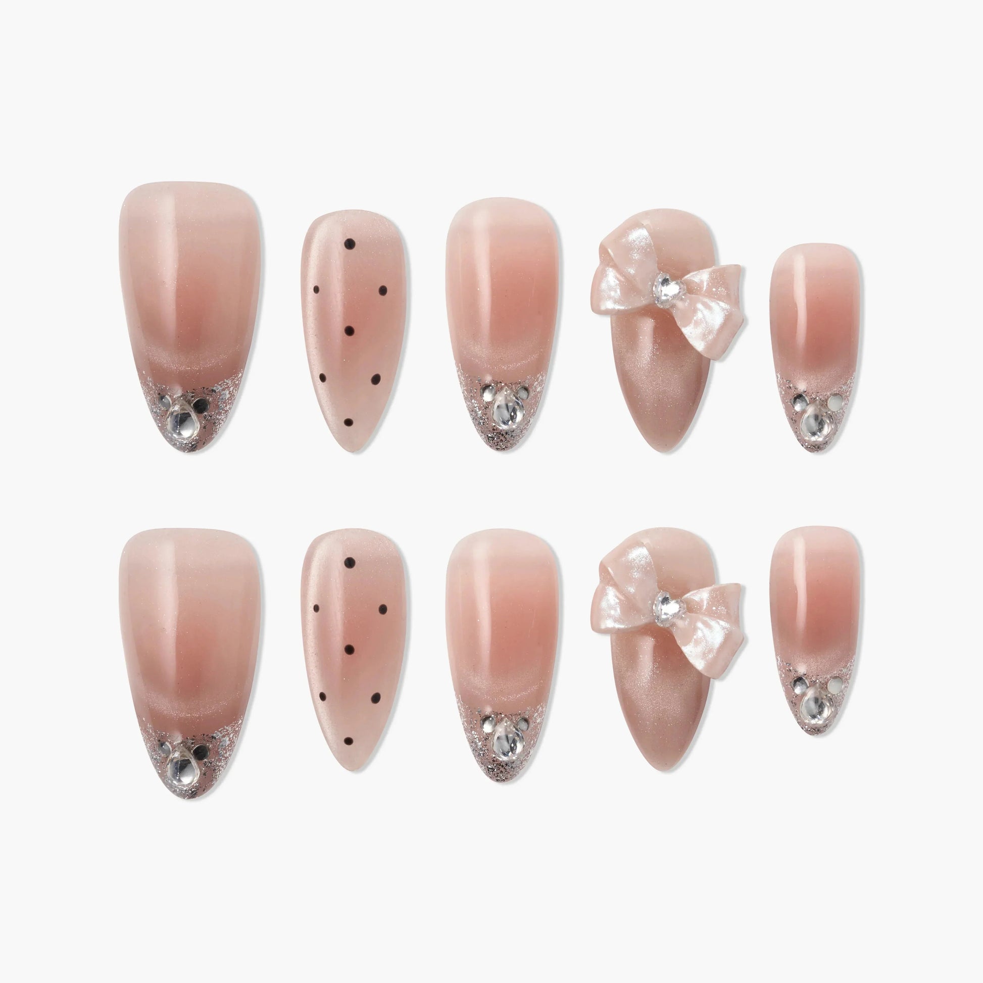 Pink press-on nails with rhinestones, polka dots, glitter tips, and decorative bows