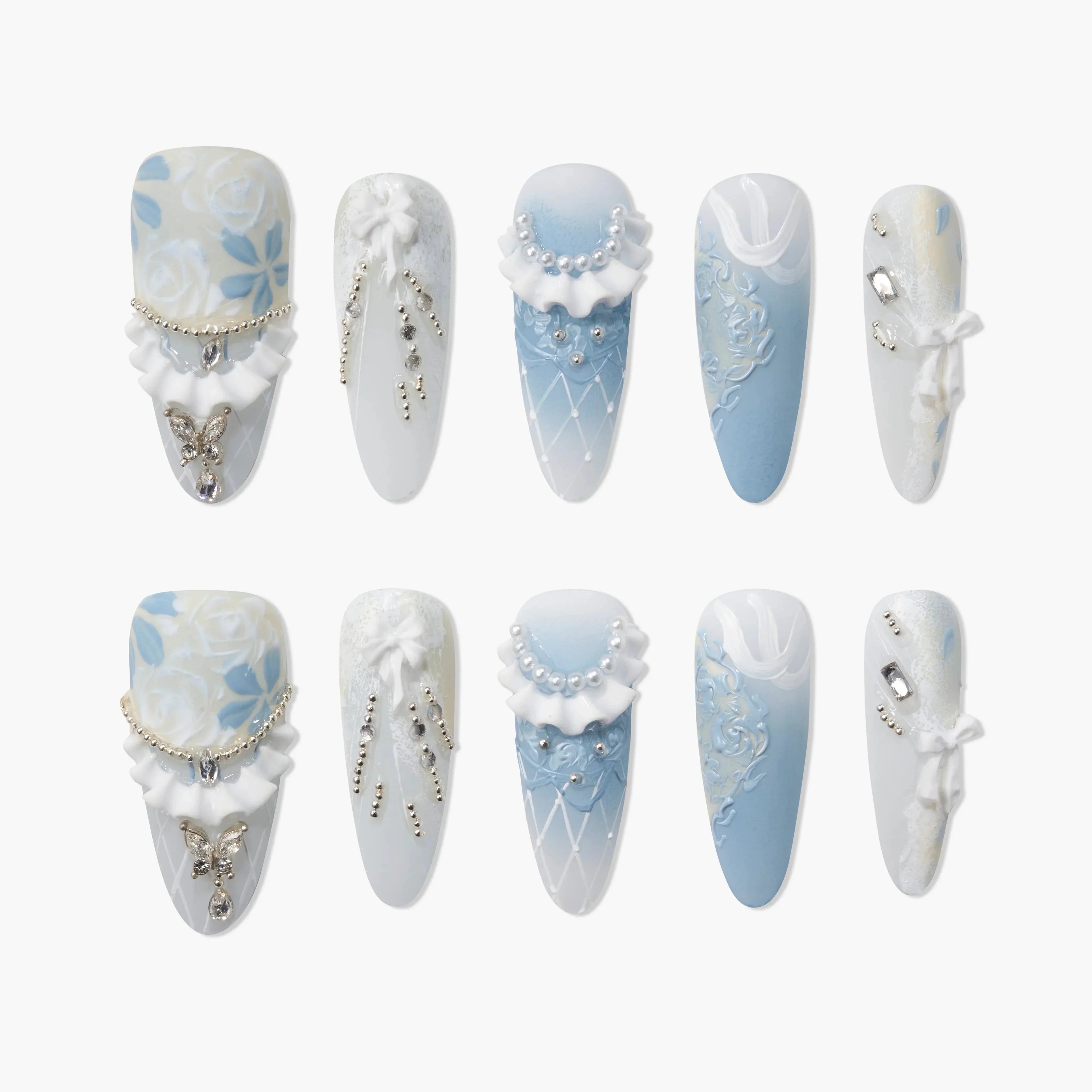 Blue and white press-on nails with 3D floral designs, pearls, bows, and jeweled accents.
