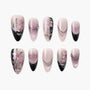 Handmade press-on nails with pink floral designs, black tips, and rhinestone accents