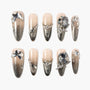 Handmade press-on nails with nude to silver ombre, rhinestones, and 3D metallic accents