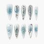 Blue and white press-on nails with silver accents, butterfly and floral designs