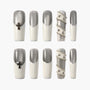 Handmade silver and white press-on nails with cross charms and metallic bead accents