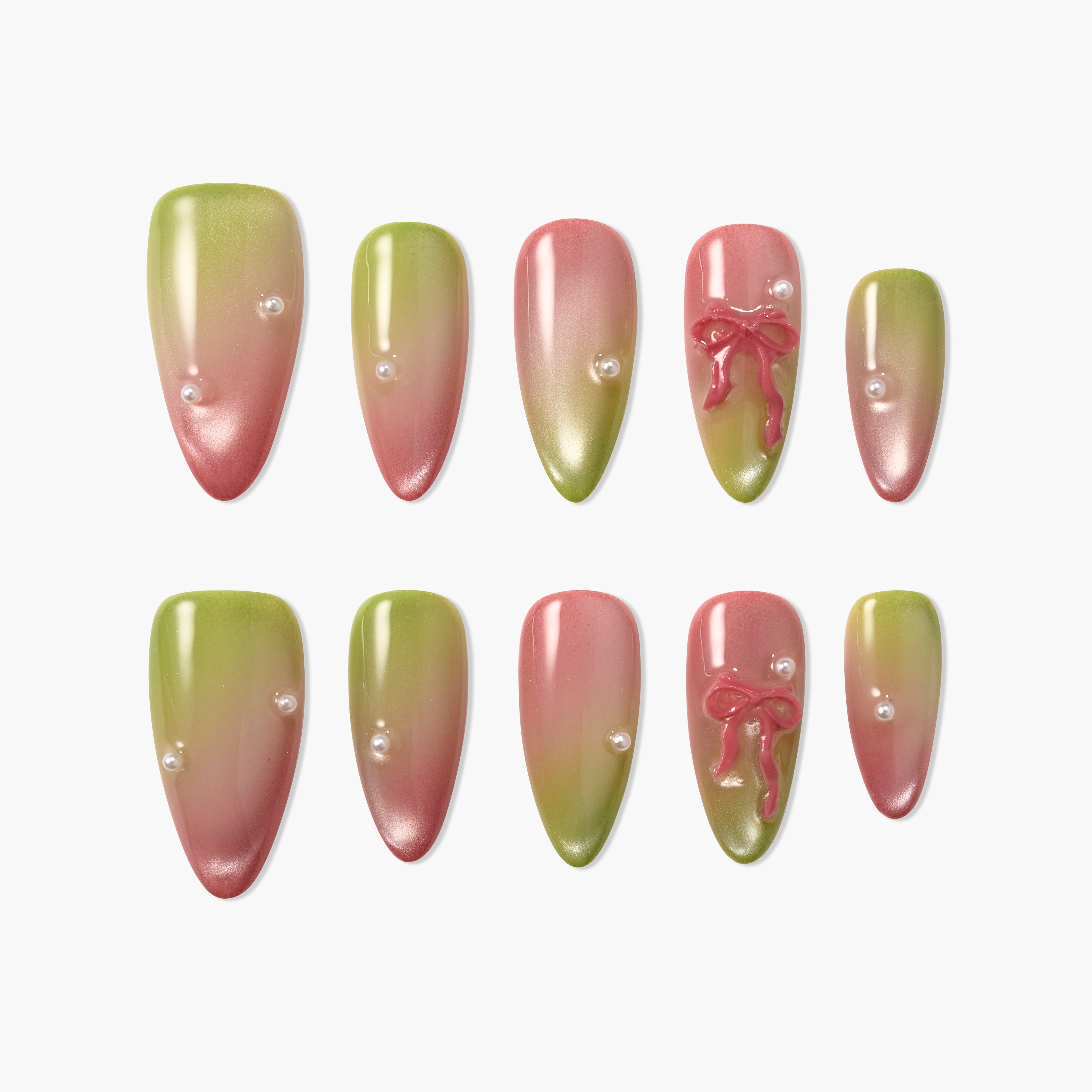 Green and pink ombre press-on nails with pearl accents and 3D bow designs, arranged on white background