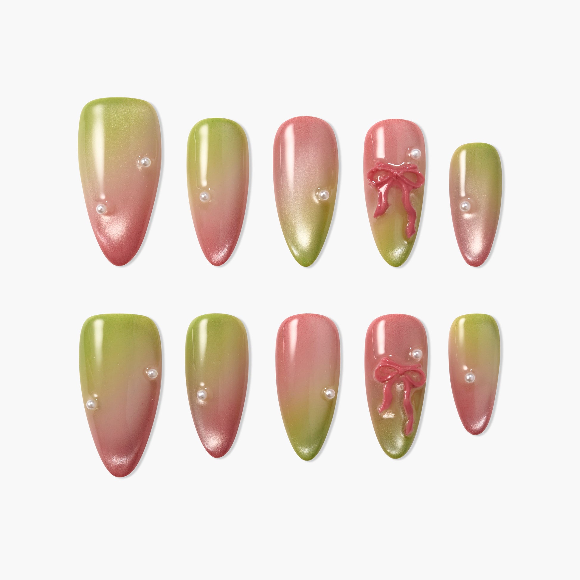 Green and pink ombre press-on nails with pearl accents and 3D bow designs, arranged on white background