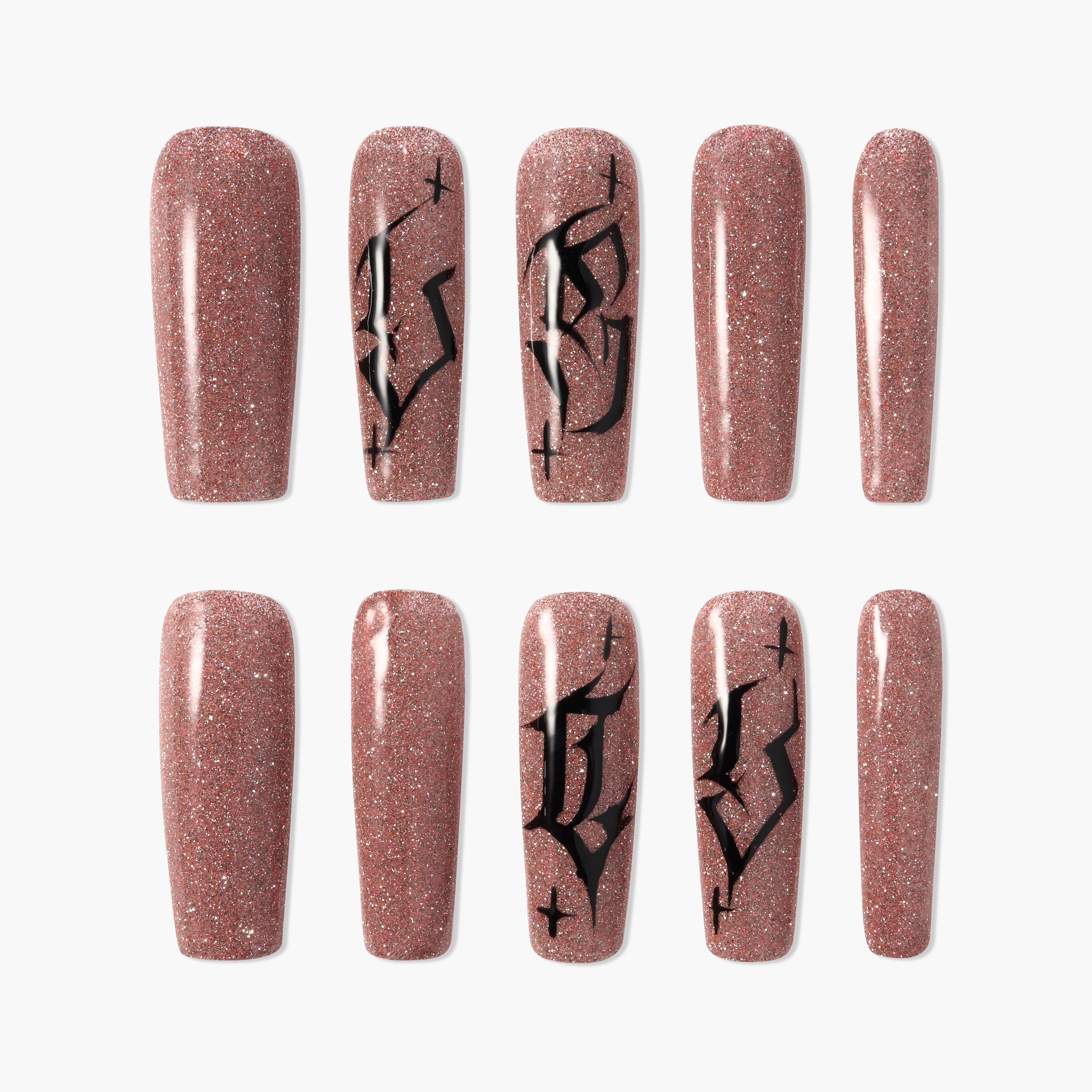 Glittery brown press-on nails with black gothic letter designs, arranged on a white background.