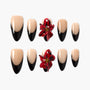Coffin-shaped press-on nails with black French tips and 3D red floral accent designs