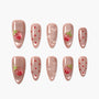 Glossy nude press-on nails with strawberry fruit designs, red dots, and bubble accents.