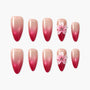 Pink ombre press-on nails with 3D flower accents, reusable, long almond shape, on white background.