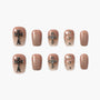 Handmade press-on nails in nude gradient with cross and rhinestone accents, glitter finish