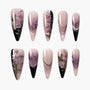 Handmade press-on nails with purple floral designs, black accents, and elegant lines
