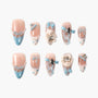 Handmade press-on nails with pastel pink and blue designs, bows, pearls, bunny charms, and rhinestones.