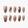 Handmade press-on nails with nude and marbled purple design, gold accents, and shimmer.
