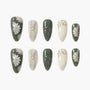 Handmade press-on nails in green and cream with daisy floral and glitter accents