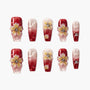 Red and pink ombre press-on nails with 3D floral accents and rhinestones, arranged on a white background.