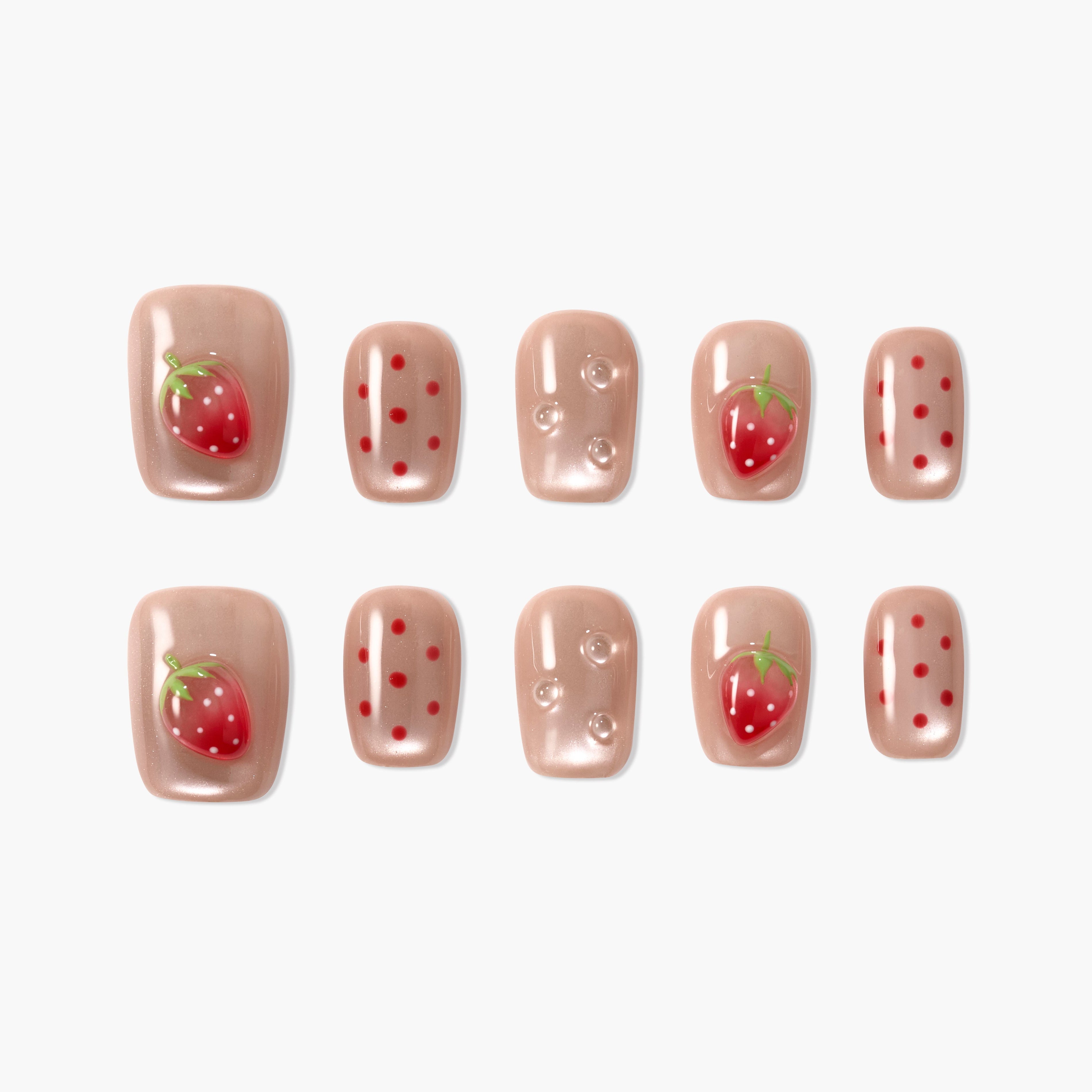 Handmade press-on nails with nude base, red strawberry art, polka dots, and gem accents.