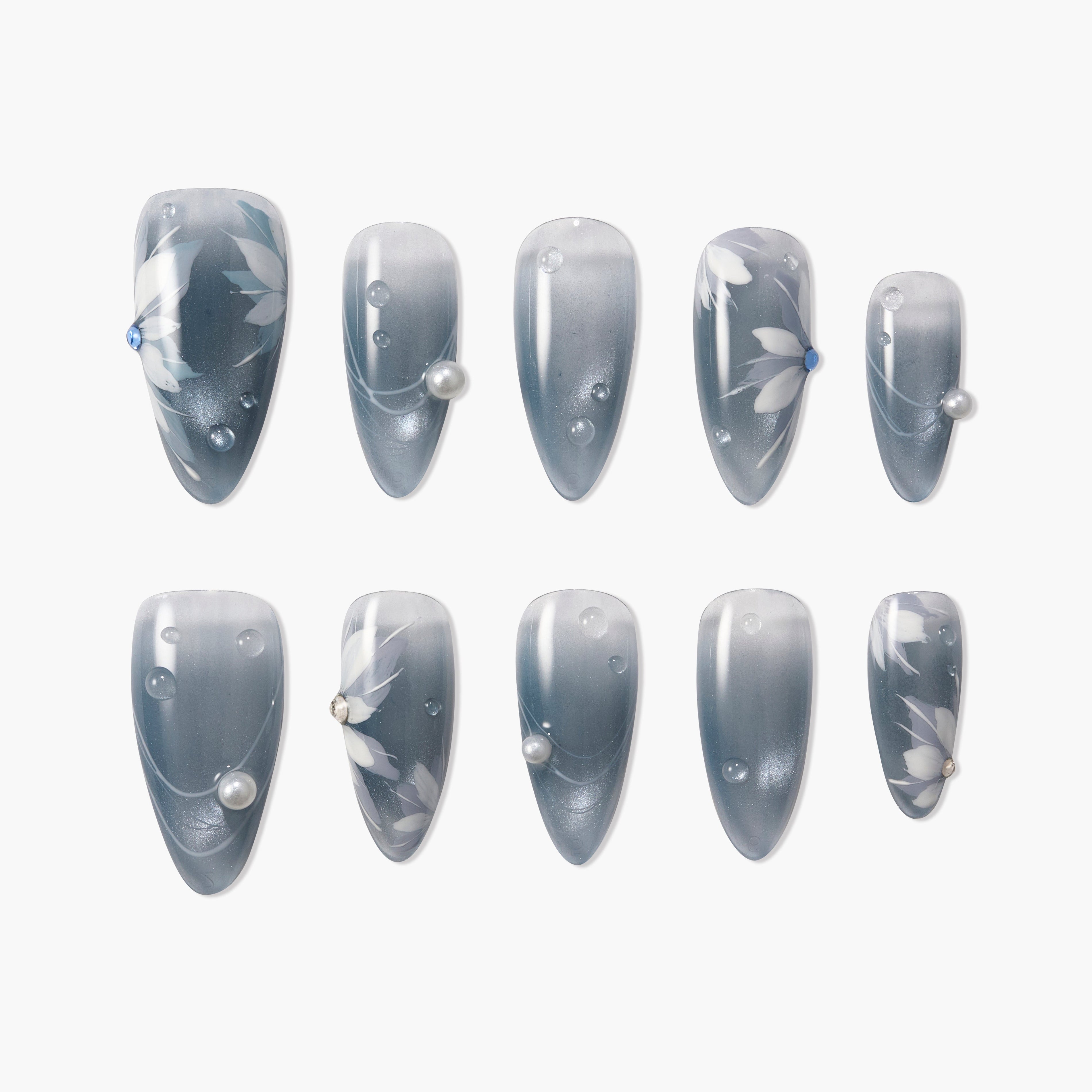Gray press-on nails with white floral designs, pearl and gem accents, glossy finish