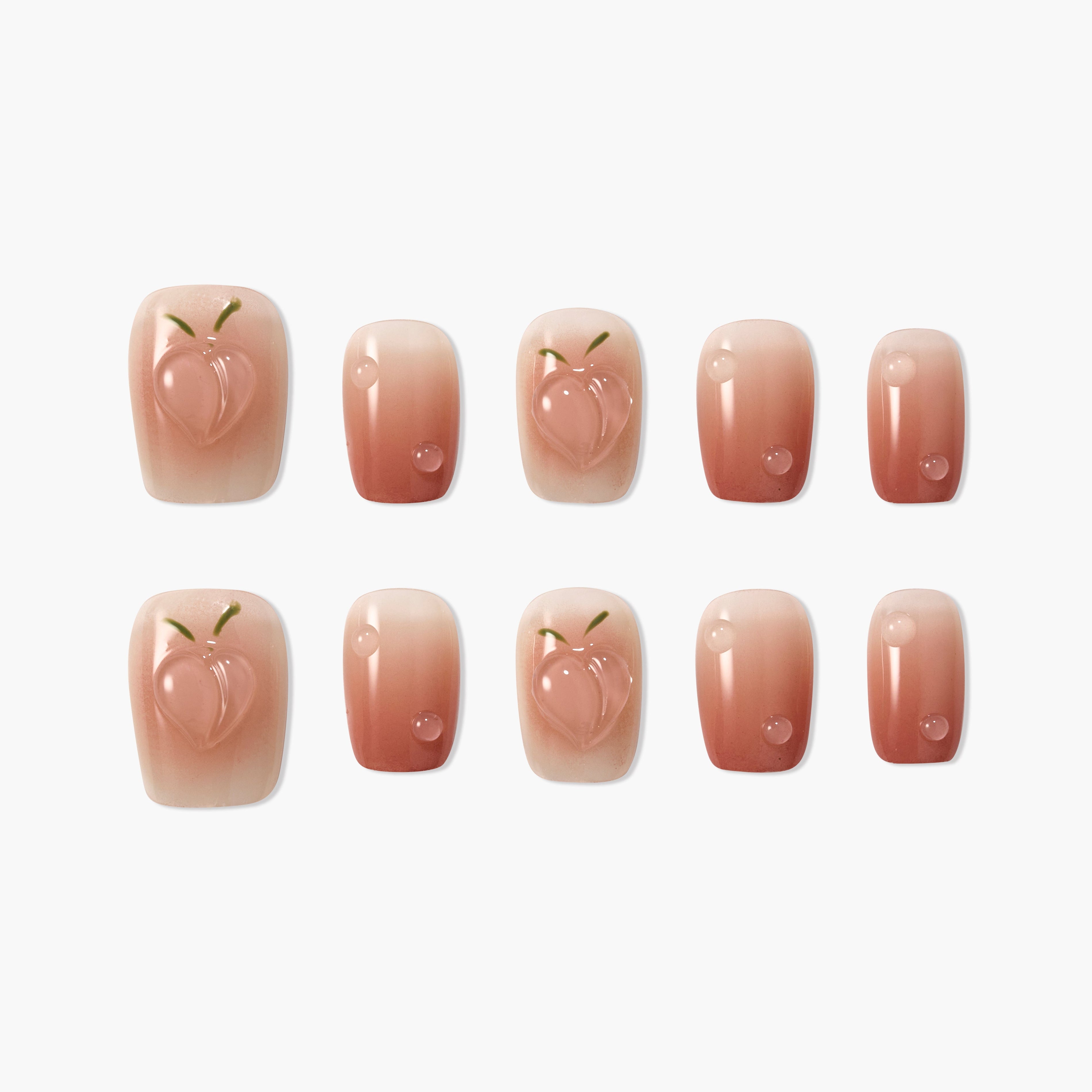 Peach design pink gradient press-on nails with glossy finish, arranged on white background