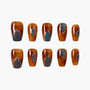 Set of brown press-on nails with blue and silver glitter design on a white background