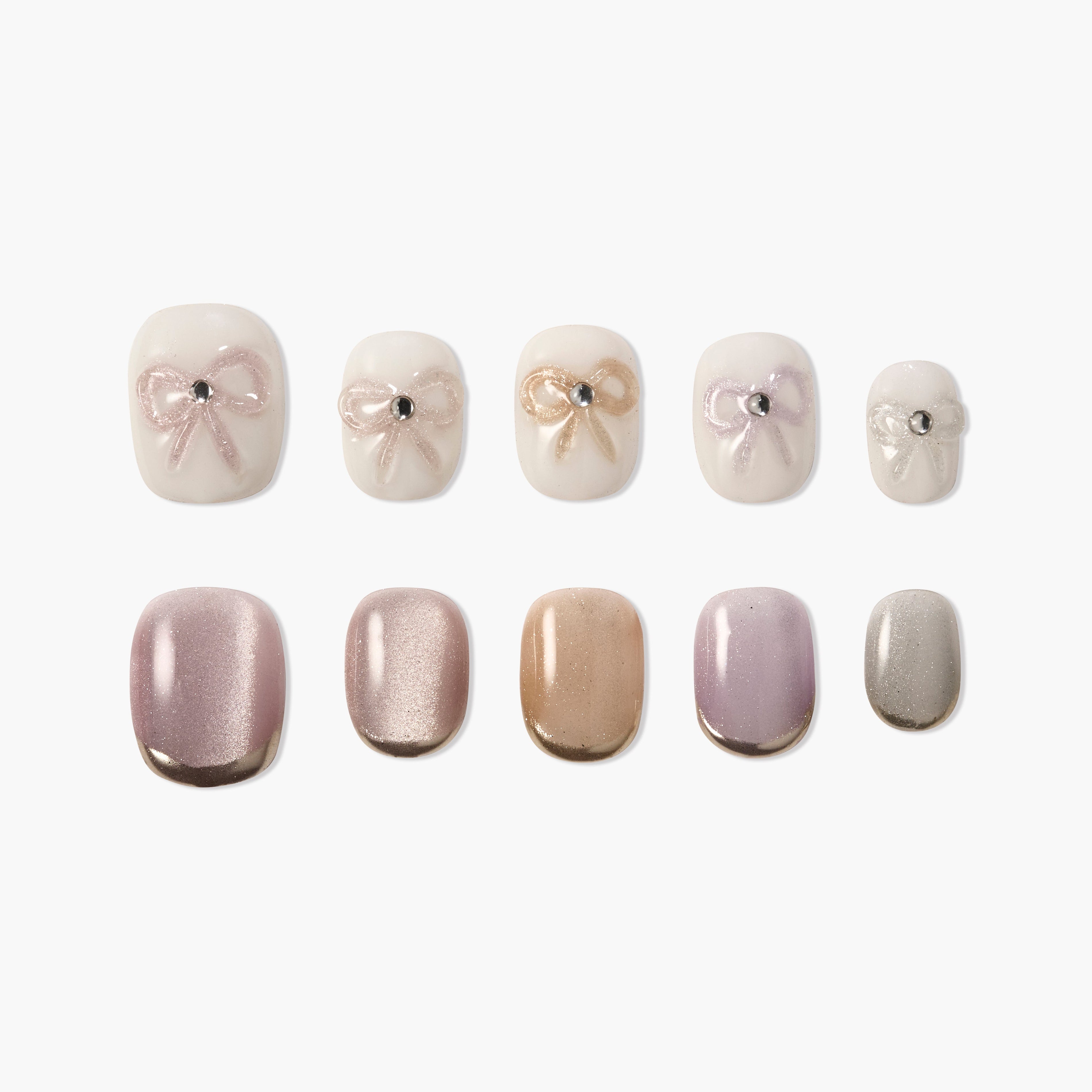 Handmade press-on nails with pastel shades, bow designs, and rhinestone accents on white background.