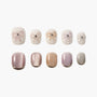 Handmade press-on nails with pastel shades, bow designs, and rhinestone accents on white background.