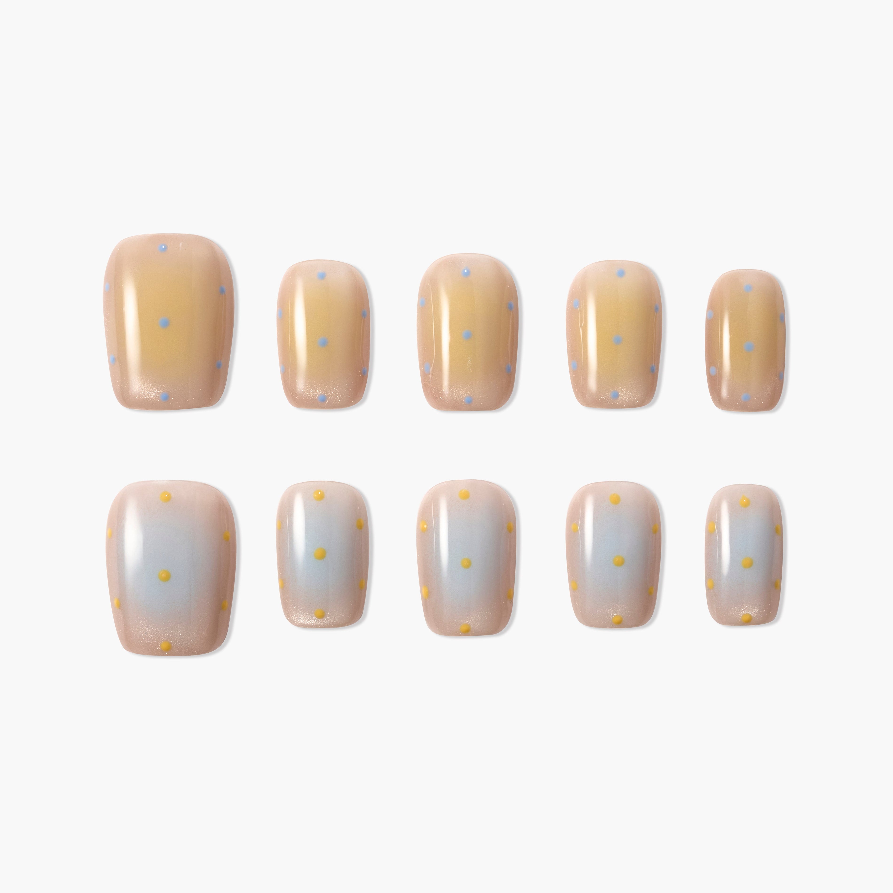 Handmade press-on nails with beige and white ombre base, pastel polka dot design