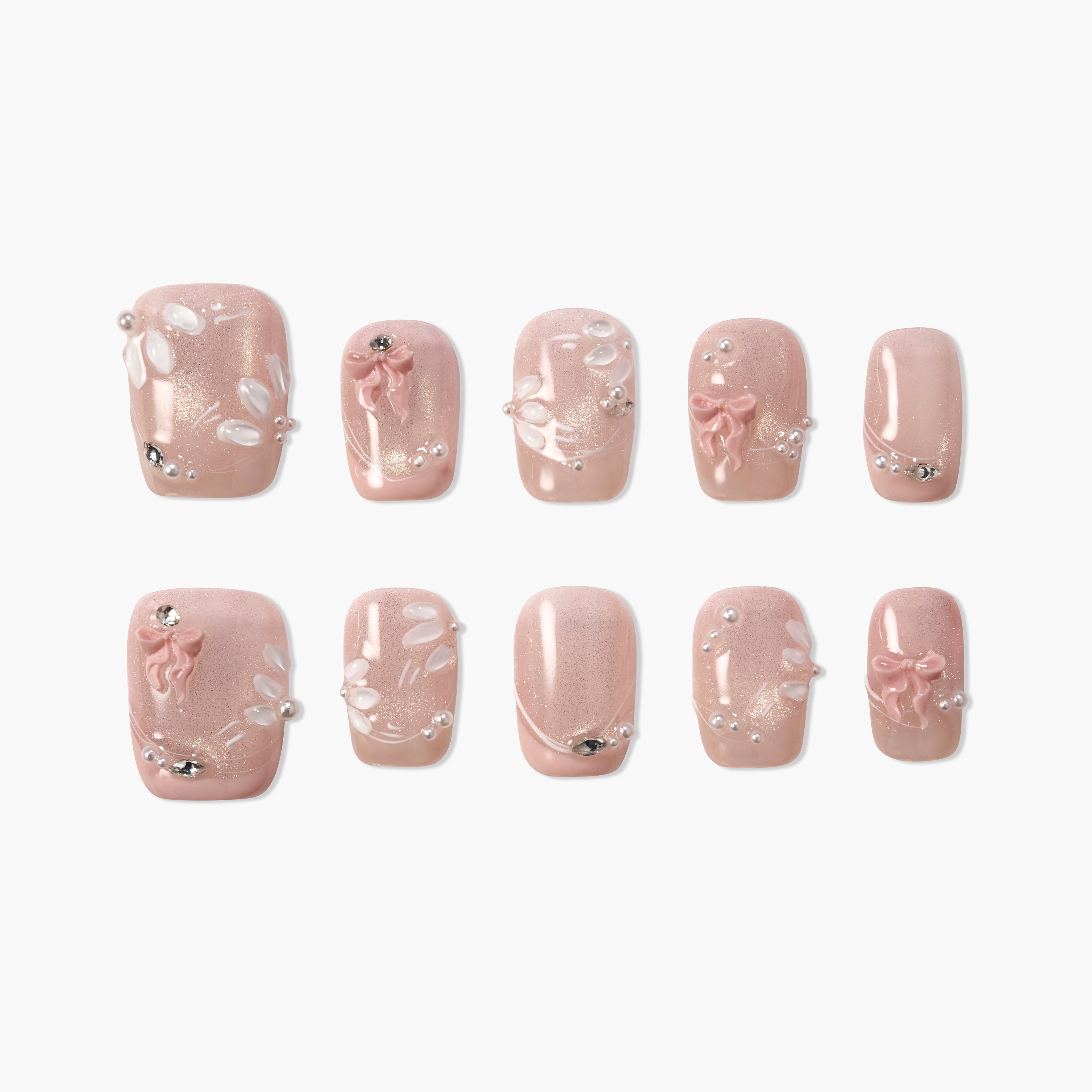 Pink press-on nails with 3D bows, pearl accents, rhinestones, and floral details