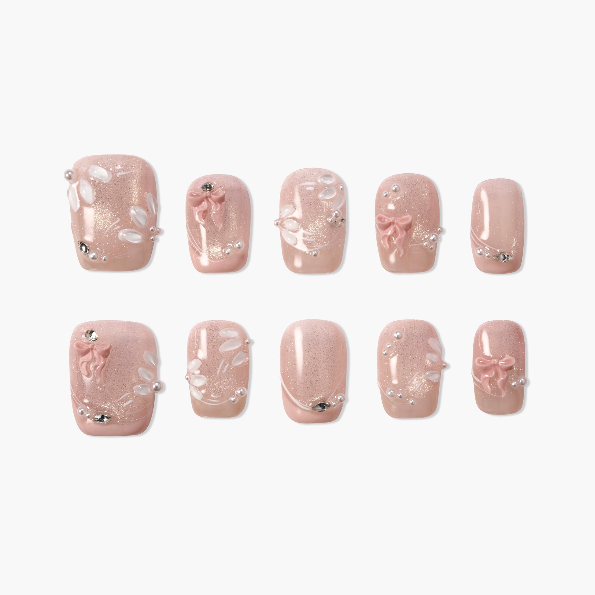 Pink press-on nails with 3D bows, pearl accents, rhinestones, and floral details