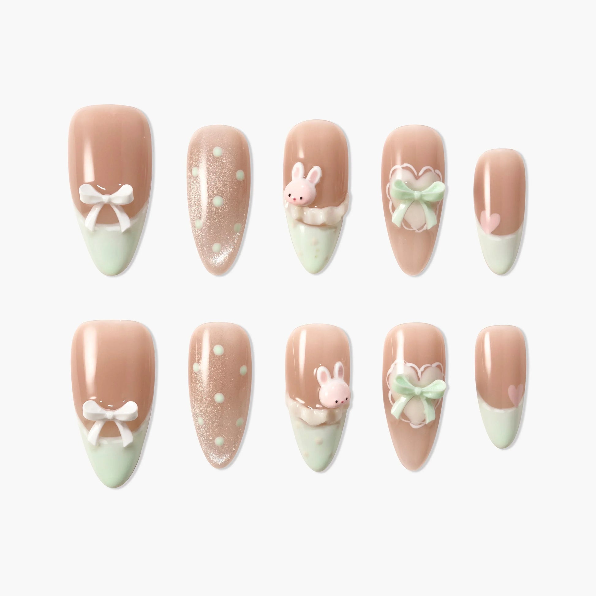 Cute pastel pink press-on nails with bows, polka dots, hearts, and 3D bunny designs.